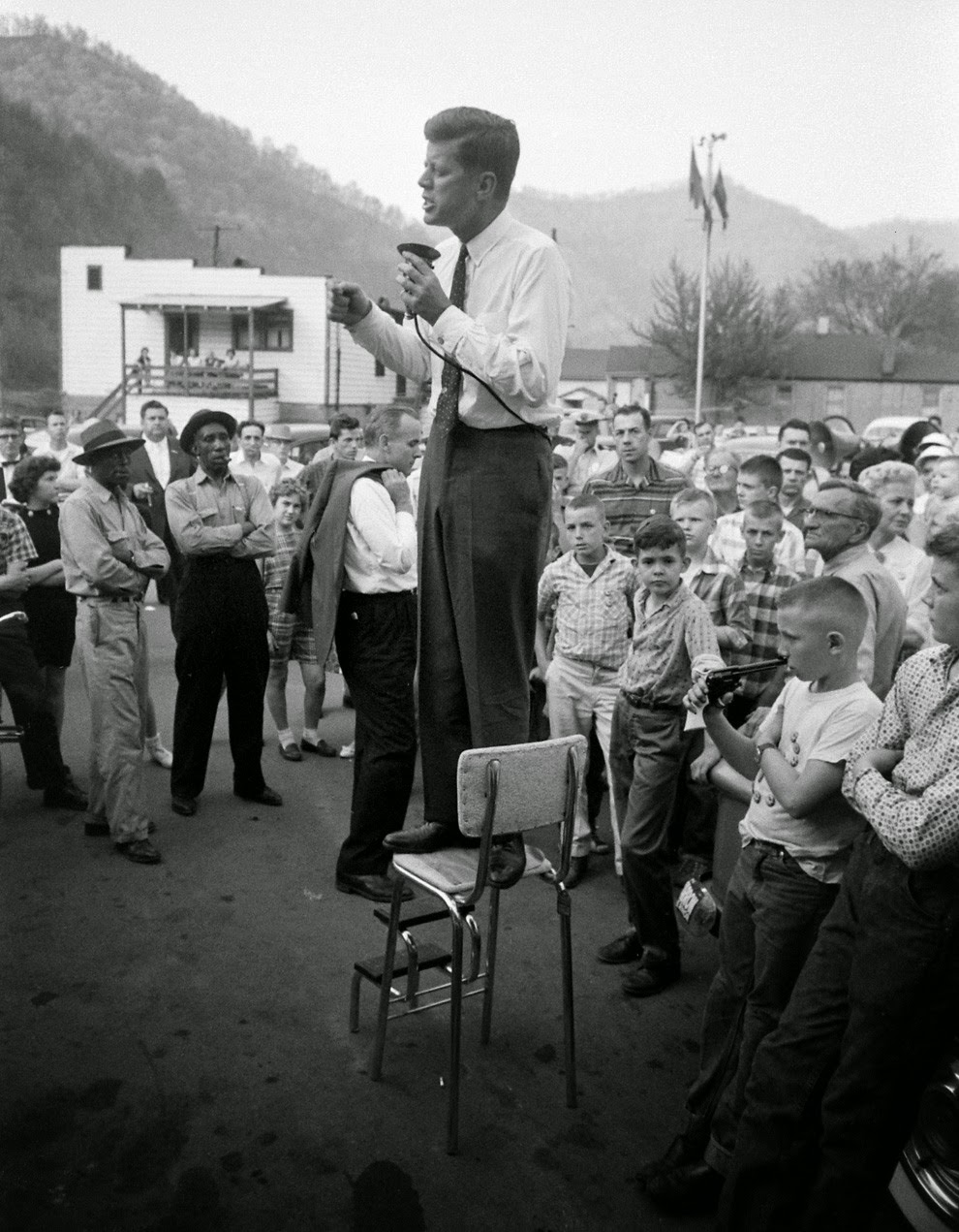 John F. Kennedy campaigns in rural West Virginia, precariously perched on a high-chair to deliver his speech. 1960.jpg